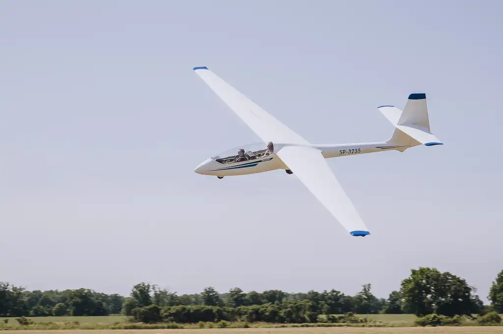 Event z serii Piąty Żywioł Powietrze, przedstawiający szybowiec podchodzący do lądowania na trawiastym pasie lotniska.