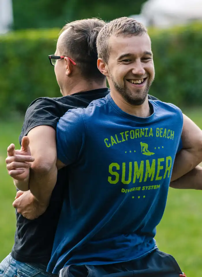 Dwaj uczestnicy wykonujący ćwiczenia rozgrzewające.