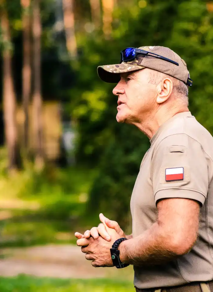 Krzysztof Przepiórka przemawia do publiczności, ujęcie z profilu.