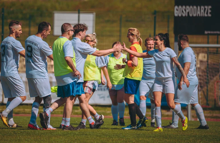 Zawodnicy gratulują sobie po meczu, prezentując gest fair play i sportowy szacunek po zakończonej rywalizacji.