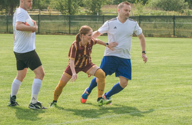 Zawodnicy biorą udział w dynamicznej akcji meczu, walcząc o piłkę podczas intensywnego fragmentu rozgrywek firmowych.