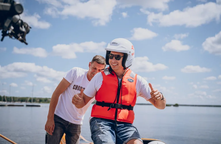 Zadowolony uczestnik wykonuje gest radości po przejażdżce motorowodnej z Bartkiem Marszałkiem podczas eventu.