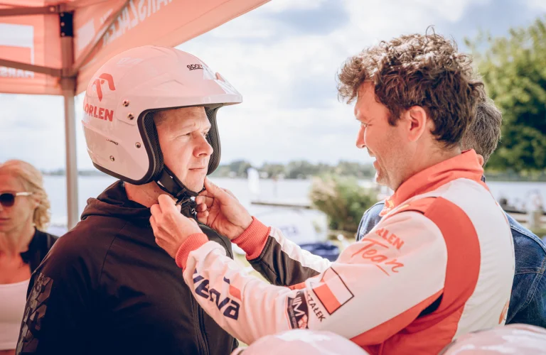 Event z serii Piąty Żywioł Woda, gdzie Bartek Marszałek zakłada kask uczestnikowi przed wodną częścią programu.