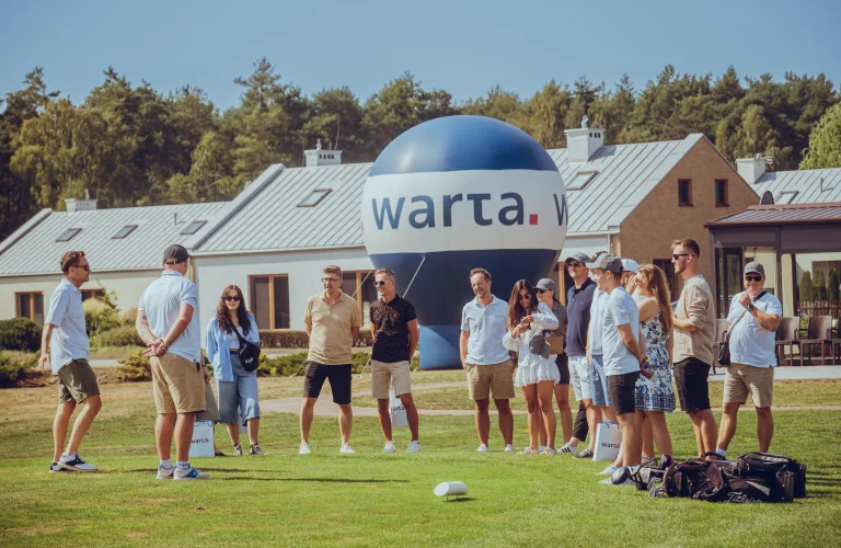 Uczestnicy eventu jadą czołgiem przez las.