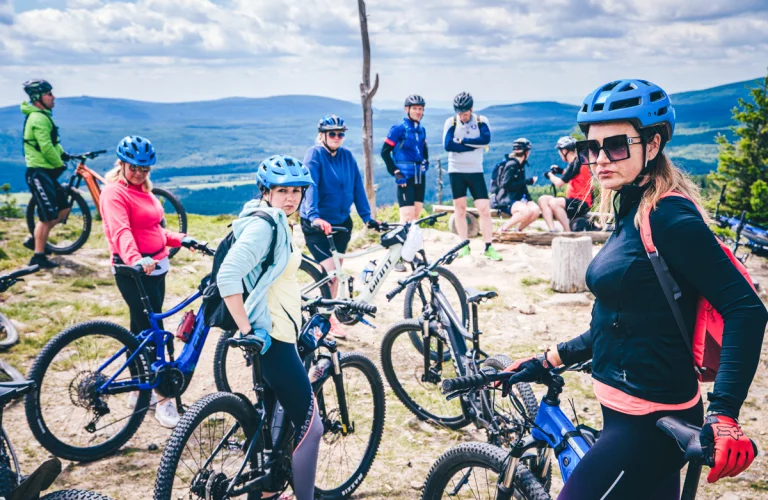 Event z serii Piąty Żywioł Ziemia, gdzie grupa uczestników stoi z rowerami na górskim punkcie widokowym.