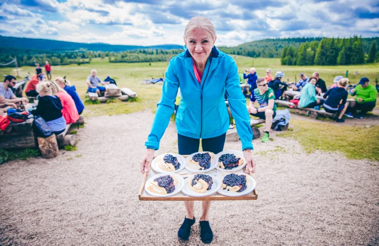 Uczestnik eventu pozuje do zdjęcia przy stanowisku cateringu podczas przerwy obiadowej.