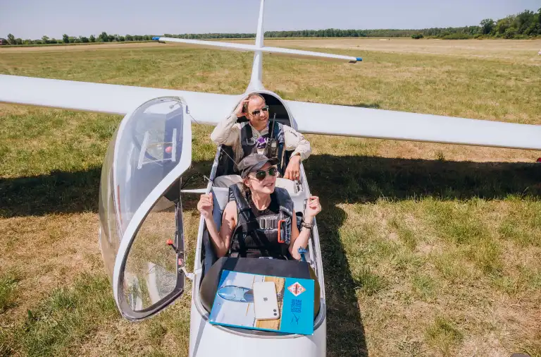 Event z serii Piąty Żywioł Powietrze z Sebastianem Kawą i uczestnikiem siedzącym w szybowcu po udanym locie.