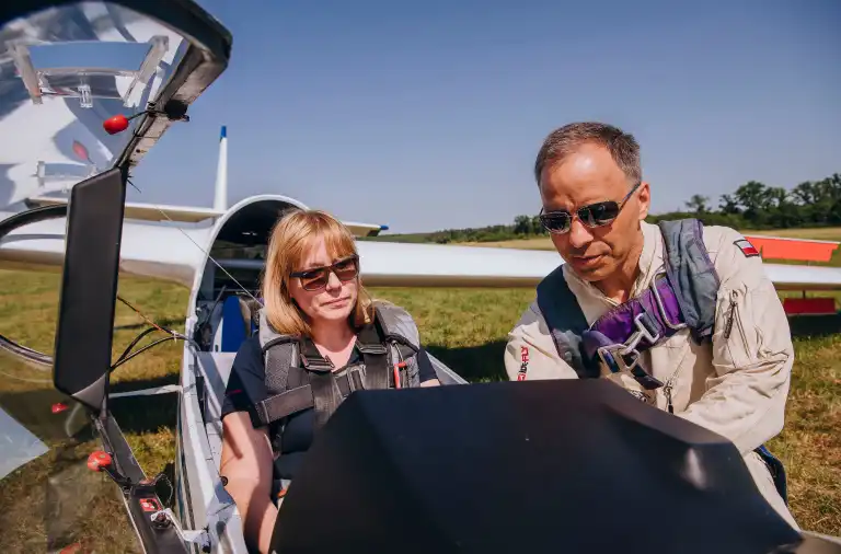 Event z serii Piąty Żywioł Powietrze, na którym uczestniczka siedzi w szybowcu, a Sebastian Kawa omawia szczegóły lotu.