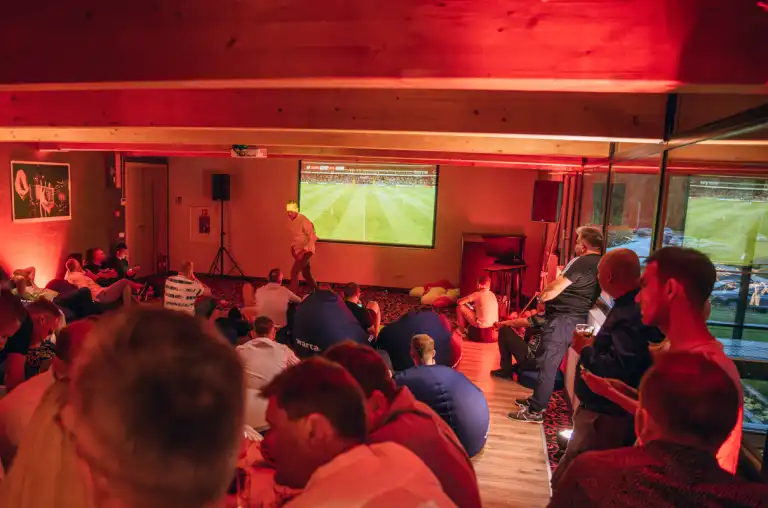 Uczestnicy siedzą przy stołach podczas uroczystej gali, czekając na wręczenie nagród po zakończonej sportowej rywalizacji.