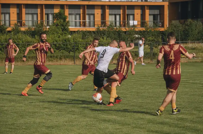 Event z serii Piąty Żywioł Ziemia, przedstawiający zawodnika w białej koszulce dryblującego pomiędzy obrońcami drużyny rywali.